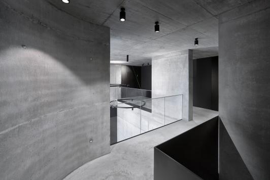 Innenansicht des Bürogebäudes Büro am Stadtbahnhof mit sichtbaren Betonflächen, offenen Raumbezügen und filigranen Glasgeländern, geplant und realisiert von arcplus Architekten