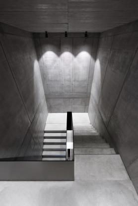 Treppen im Bürogebäude Büro am Stadtbahnhof mit klar geführter Sichtbetontreppe, reduzierter Materialgestaltung und gezielter Beleuchtung, geplant und realisiert von arcplus Architekten