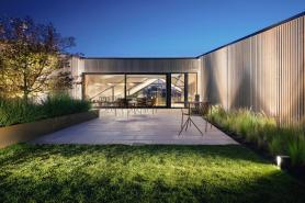 Blick auf die Dachterrasse des Bürogebäudes Büro am Stadtbahnhof mit klar gegliederten Ruhezonen, begrünten Randbereichen und direktem Bezug zum Innenraum als besonderer Aufenthaltsort, geplant und realisiert von arcplus Architekten Freudenstadt